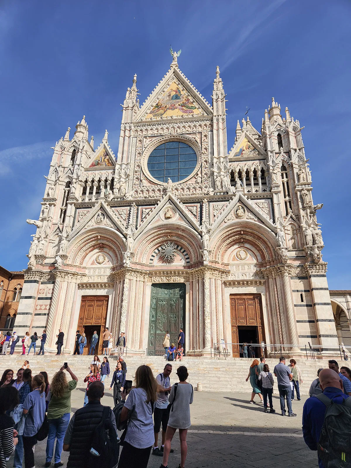 Fachada frontal do Duomo com seus três portais elaborados e rosácea central