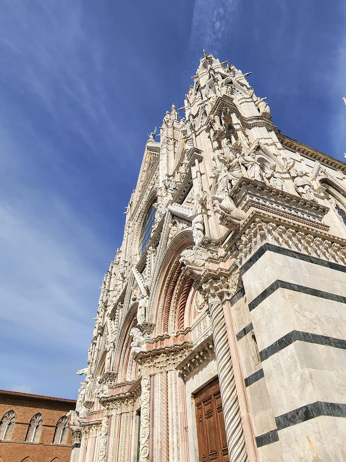 Detalhe do portal gótico — esculturas, arquivoltas e pináculos que se erguem ao céu