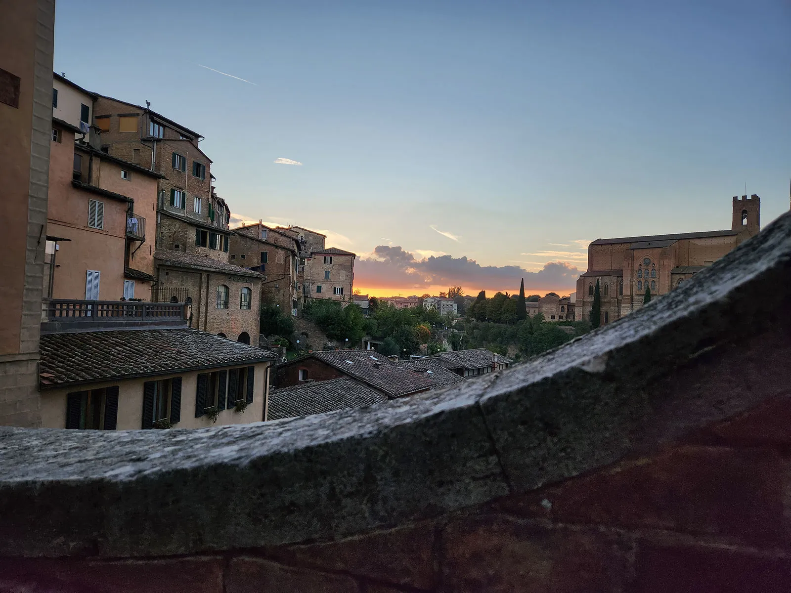 Entardecer em Siena com luz dourada sobre os telhados de terracota